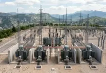EBRD Boosts Bosnia and Herzegovina Power Grid Modernization Electrical substation with three large transformers in concrete basins, copper piping, and tall transmission pylons against a mountainous landscape in the distance.