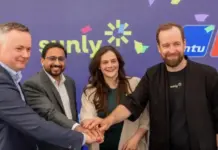 Sunly, Rolls-Royce Pair Up for Baltic Battery Storage System Four professionals join hands in a circle, smiling, with a Sunly-branded backdrop behind them.