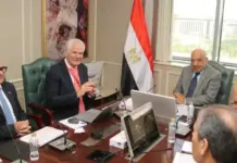 Egypt Boosts Sinai Clean Energy Project Development Group of five men in suits sit around a conference table with laptops, water bottles, and documents; a tall Egyptian flag stands by the window.